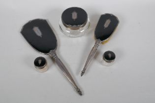 An antique sterling silver and black enamel dressing table set, including a hand mirror, brush,