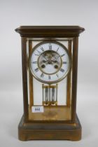 A C19th French brass mantel clock with a mercury pendulum and enamelled chapter ring with Roman