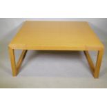 A contemporary blond oak coffee table, raised on square end supports, 120 x 120 x 48cm
