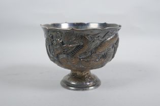 An antique Japanese antimony stem bowl with raised dragon decoration, indistinct mark to base,