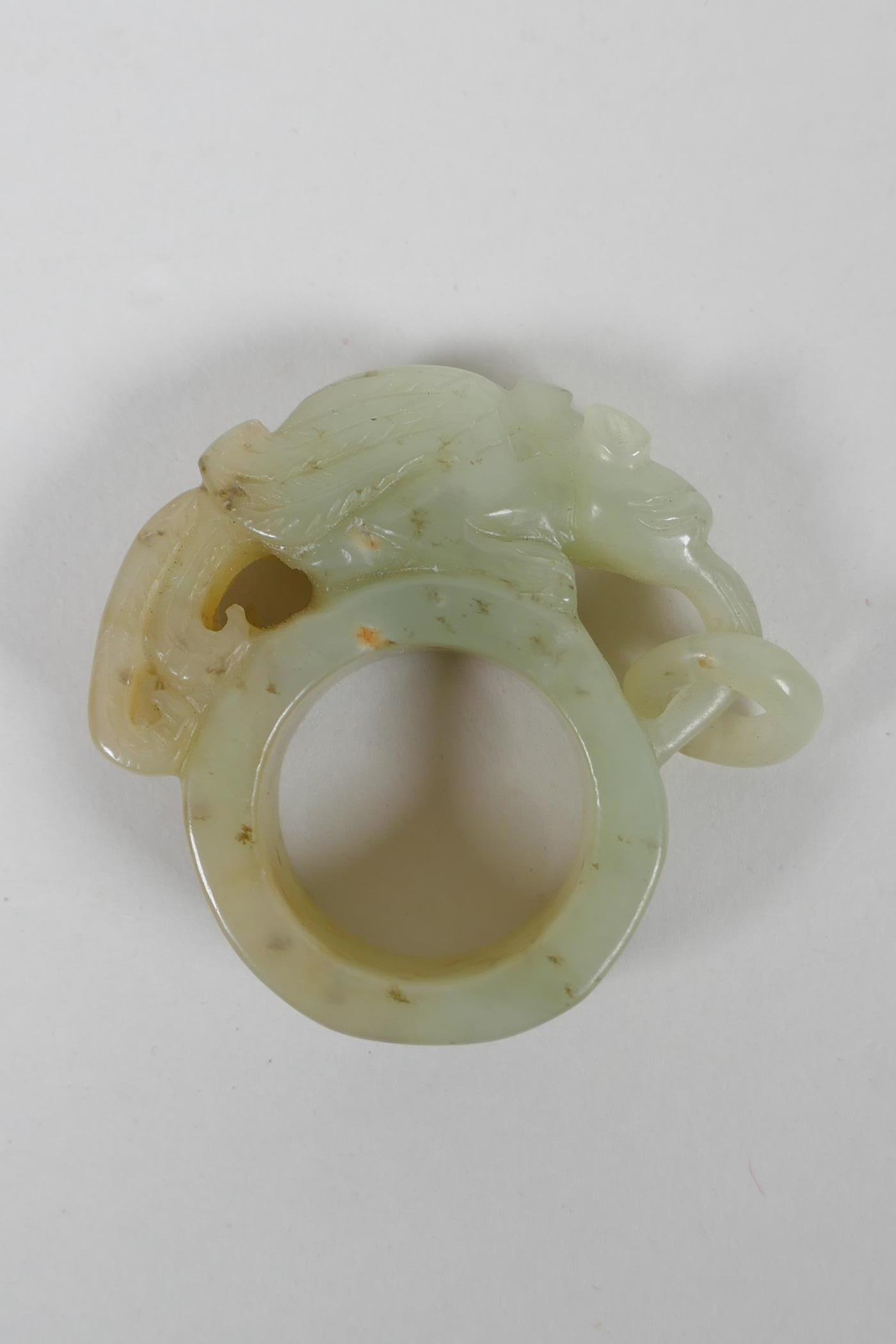 A Chinese Nephrite archers thumb ring with carved mythical creature decoration