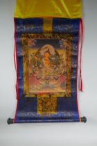 A Tibetan printed thangka in a silk scroll mount with gilt illuminated details, 48 x 62cm