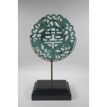 A Chinese carved mottled green jade/hardstone rondel with auspicious symbol and dragon decoration,