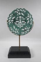 A Chinese carved mottled green jade/hardstone rondel with auspicious symbol and dragon decoration,