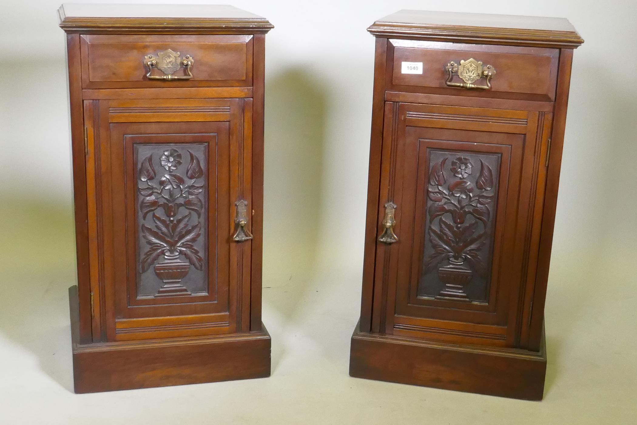 A pair of Victorian walnut bedside cabinets with single drawer over carved cupboard door, raised