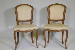 A pair of C19th French beechwood side chairs with carved decoration and brass stud detail