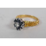 An 18ct gold cluster ring, set with six sapphires and a central diamond, size K, 4g