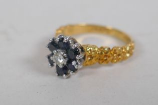 An 18ct gold cluster ring, set with six sapphires and a central diamond, size K, 4g