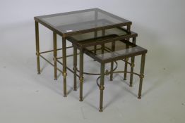 A mid century nest of three brass occasional tables with tinted glass tops, 56 x 46 x 47cm