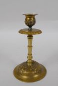 An unusual brass candlestick with Arabic inscription to the base and raised insect decoration,