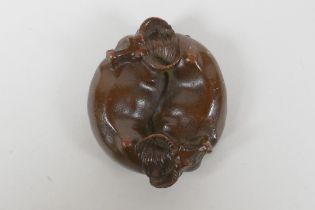 An oriental cast bronze rondel in the form of two water buffalo and a Yin Yang emblem, 6cm diameter