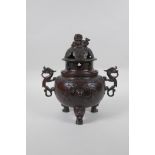 A Chinese bronze two handled censer and cover on tripod feet, with kylin decoration and knop,