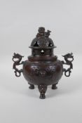 A Chinese bronze two handled censer and cover on tripod feet, with kylin decoration and knop,