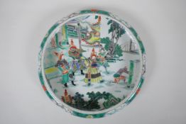 A famille vert porcelain dish with rolled rim, decorated with warriors in a landscape, Chinese