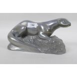 A cold cast metal figure of an otter, signed, 27cm long