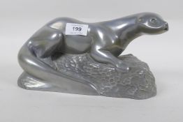 A cold cast metal figure of an otter, signed, 27cm long