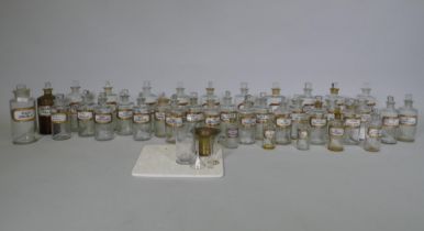 A collection of Victorian glass apothecary bottles, all with stoppers and inset gilt labels, largest