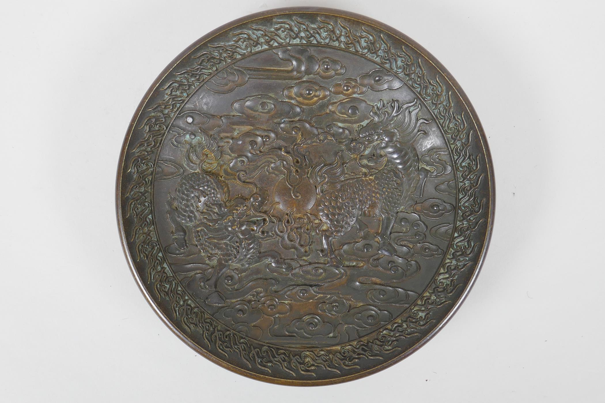 A Chinese bronze dish with raised kylin decoration, Xuande 4 character mark to base, 18cm diameter