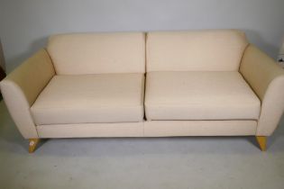 A contemporary design two seater sofa with linen covers, raised on splay supports, 188cm wide