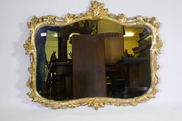 A carved and gilded pine wall mirror with oak and acorn decoration, early C20th, 114 x 92cm