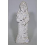 An antique carved weathered marble flat back figure of a barefoot monk holding a book, 50cm high