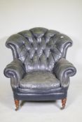 A Victorian style button back leather armchair, with scroll arms, fan back and studded detail,