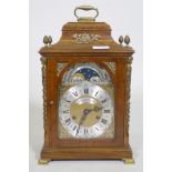 A burr walnut cased bracket clock, the brass dial with sun and moon phase, silvered chapter ring and
