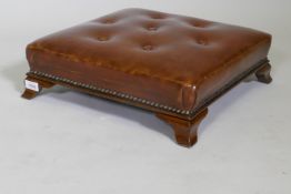 An antique button leather footstool, raised on swept supports, 46 x 46 x 13cm