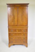 A mahogany tallboy cabinet with two cupboards over a brushing slide and four drawers, raised on