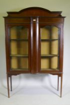 An Edwardian mahogany display cabinet with painted decoration and two doors raised on tapering