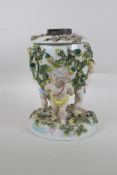 An antique continental porcelain oil lamp converted to electricity, decorated with three winged