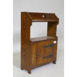 An Arts and Crafts oak cabinet with pierced decoration and metal mounts, 38 x 17 x 55cm