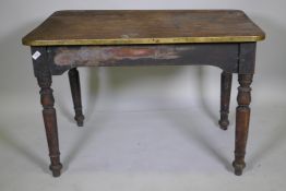 A C19th mahogany tavern type table, the one piece top with brass edge, raised on turned supports,