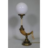 A table lamp in the form of a ram's horn, with brass mounts and opaline glass shade, 68cm high
