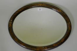 A 1920s oval wall mirror with raised chinoiserie decoration and inset bevelled glass, 58cm wide