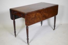 A Georgian drop leaf Pembroke table, with single end drawer, raised on ring turned tapering supports