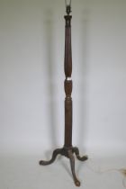An antique mahogany standard lamp with carved reeded column and tripod supports, 145cm high