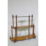 A C19th satinwood hanging wall shelf with thee shaped tiers united by faux bamboo turned supports