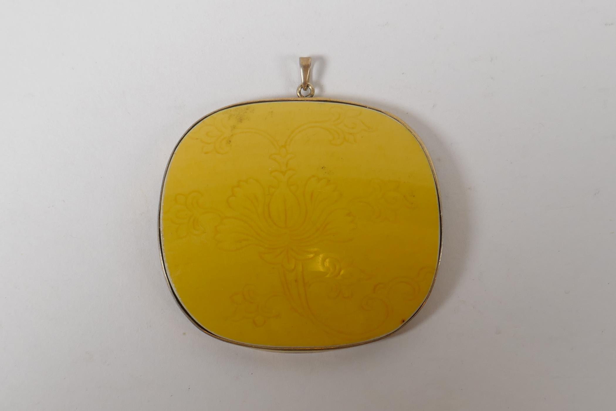 A Chinese imperial yellow porcelain shard in a yellow metal pendant mount, 6cm x 5.5cm