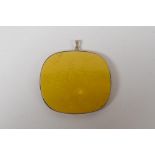 A Chinese imperial yellow porcelain shard in a yellow metal pendant mount, 6cm x 5.5cm
