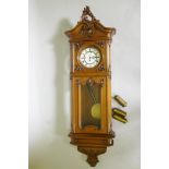 A fine C19th Vienna wall clock in walnut case with carved and applied moulded detail, the brass