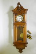 A fine C19th Vienna wall clock in walnut case with carved and applied moulded detail, the brass