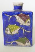 An Iznik ceramic flask decorated with fish on a blue glaze, 15cm high