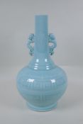 A Chinese celadon glazed porcelain bottle vase with two handles and underglaze archaic style