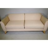 A contemporary design two seater sofa with linen covers, raised on splay supports, 188cm wide