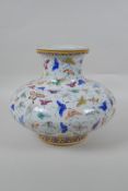 A Chinese polychrome porcelain vase of squat form with all over butterfly decoration, GuangXu 6