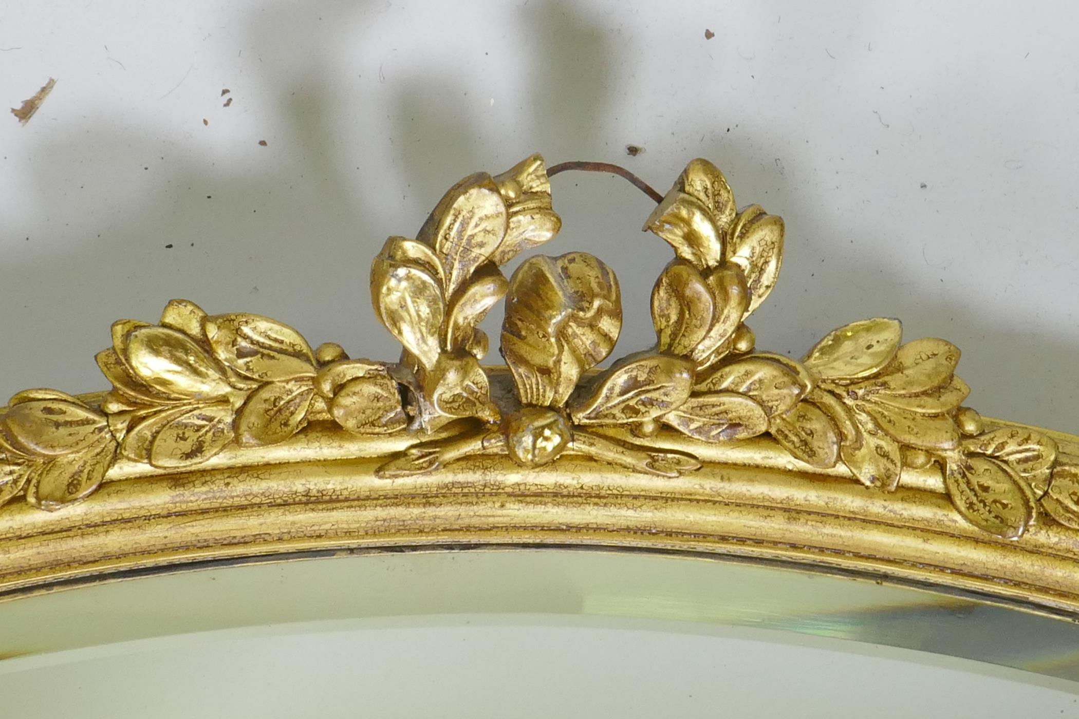 A gilt oval mirror with bevelled glass, AF losses, 82 x 60cm - Image 2 of 4