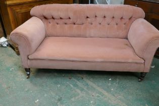 A Hampton & Sons, London, two seater Chesterfield sofa raised on turned front supports and brass