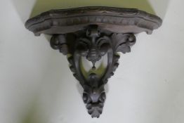 A C19th carved walnut wall bracket, 40cm wide, 29cm high