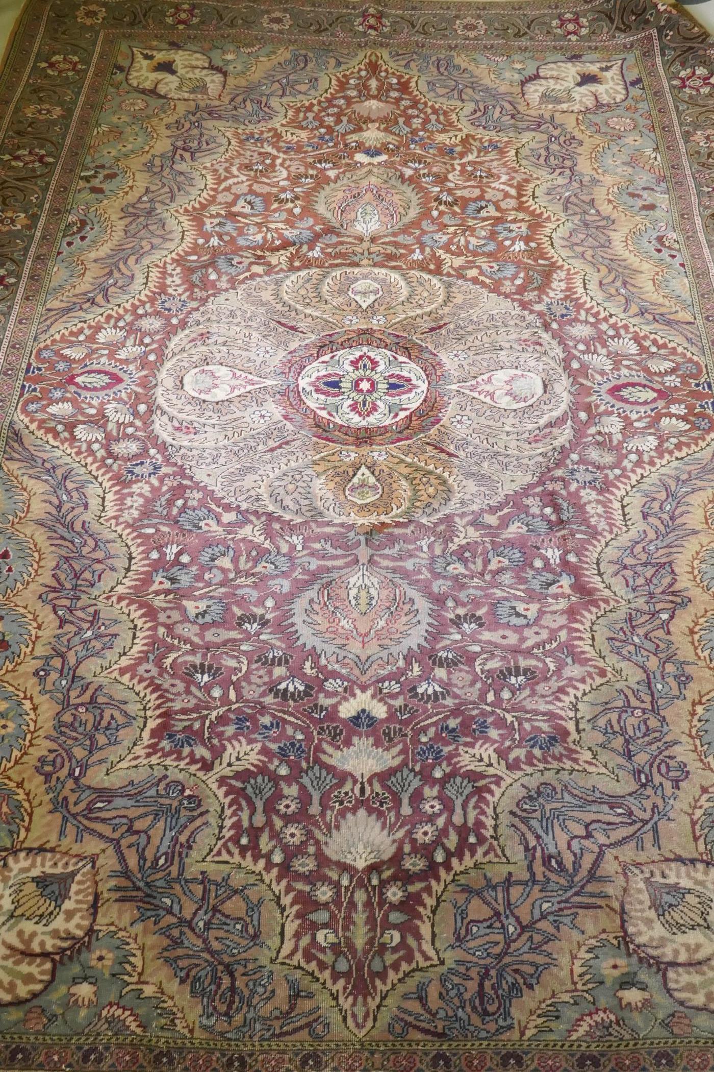 A Turkish Hereke wool carpet with central design on a faded terracotta field, with blue/grey - Image 2 of 8